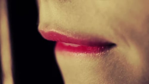 Gros plan des lèvres, une femme sexuelle se mord les lèvres, rouge à lèvres rouge sur les lèvres des mannequins de mode, maquillage, sexuel