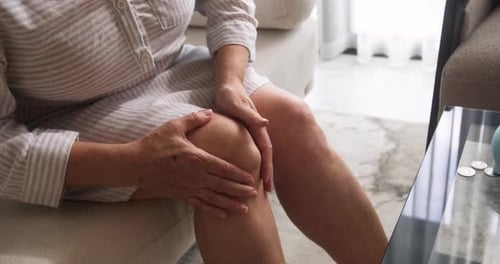 Primer plano de las manos de un jubilado frotándose un quiste poplíteo o sinovial Una hinchazón llena de líquido que