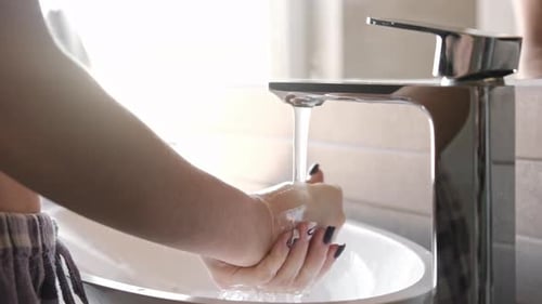 Mädchen wäscht sich die Hände in der Badewanne, Badezimmermischer und Waschbecken