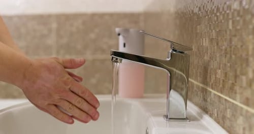 Man Washes His Hands with Foamy Soap in the Bathroom Daily Hygiene Routine
