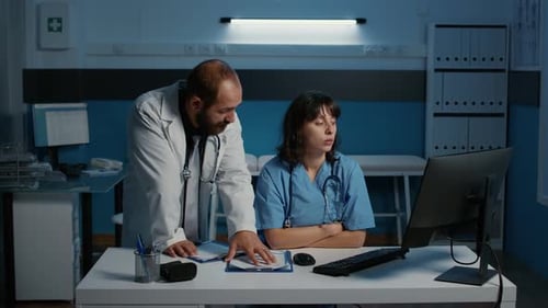 Equipo que analiza la experiencia médica en una computadora discutiendo el diagnóstico de la enfermedad del paciente