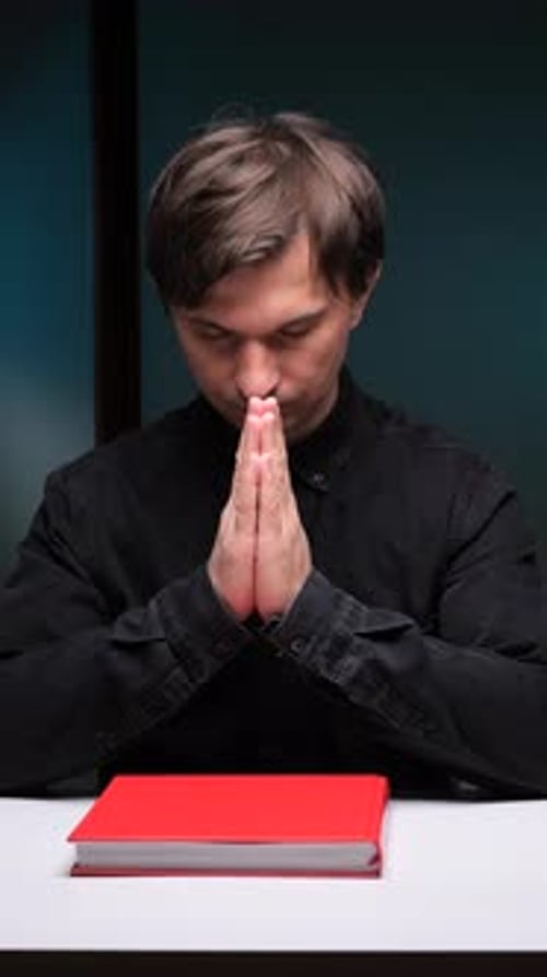 Vertical Video Businessman Praying with a Red Book on the Table