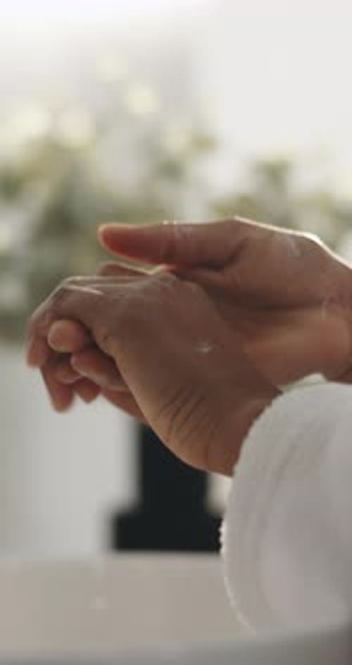 Soap, water and person washing hands in bathroom for hygiene, health or wellness in home