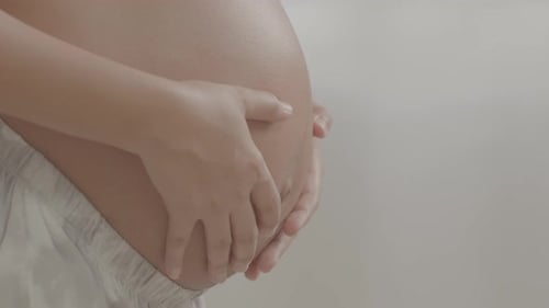 Expecting woman laying her hand on her abdomen