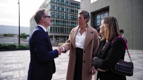 Business People Shaking Hands to Close a Work Deal Standing Outside Financial District