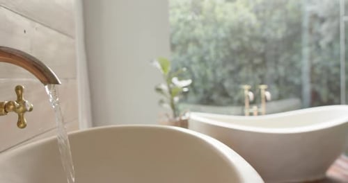 Nahaufnahme eines Waschbeckens mit fließendem Wasser im Badezimmer, Zeitlupe