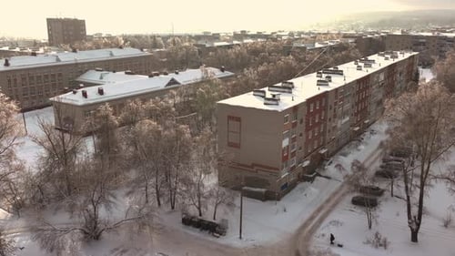 Long Residential Buildings with Roofs Covered with Snow