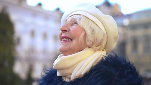 Closeup Happy Senior Greyhaired Woman with Grey Eyes Looking Away and Looking at Camera Smiling