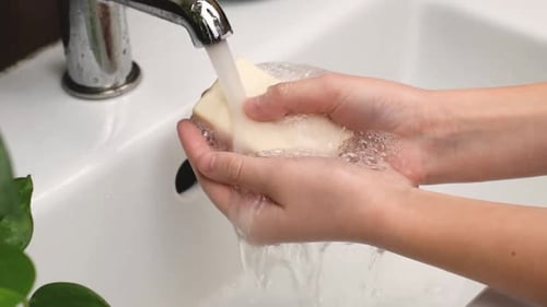 Young Girl Washing Hands with Soap Over Sink Under the Faucet Hand Disinfection During a Coronavirus