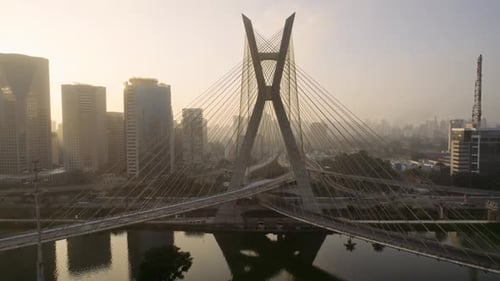 Amanecer dorado sobre un impresionante puente moderno en un ajetreado paisaje urbano