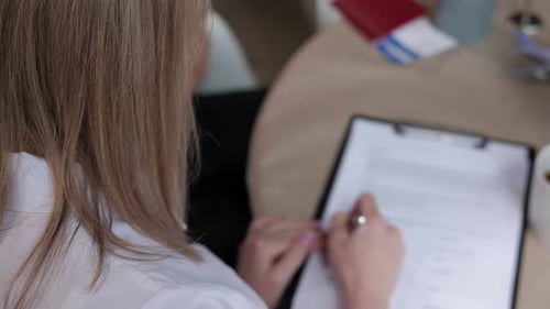 A Woman Signs a Contract for the Provision of Travel Services at a Travel Agency