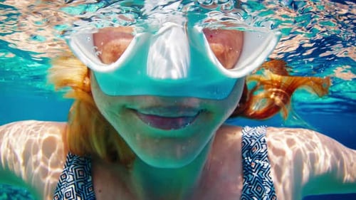Underwater portrait. Woman with mask swims in the tropical sea