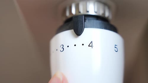 A Woman's Hand Turns the Battery Heating Knob Heating in an Apartment at Home Heating Prices
