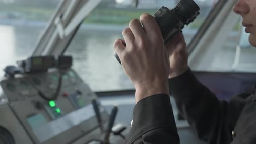 Ship Captain Looking Through Binoculars on the Bridge Clip