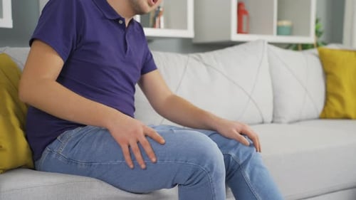 Homem com dores nas pernas e nos joelhos.