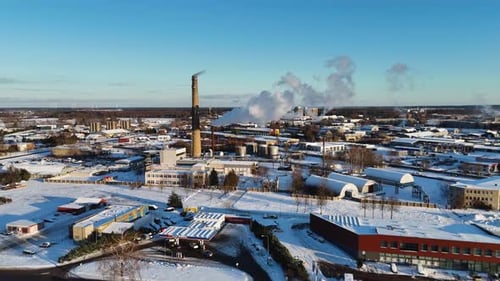 Cinematic drone shot of industrial landscape, Steam coming out of chimney, Silute, Lithuania