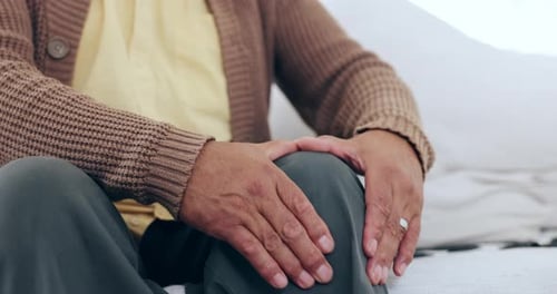 Senior, man and massage knee for pain, injury or orthopedic wound on couch