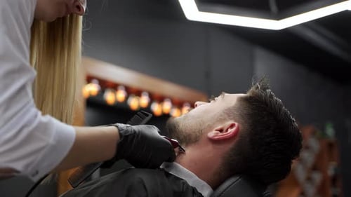 Professional Barber Gives Stylish Haircut to Male Client in Modern Salon Expert Hairdresser Uses