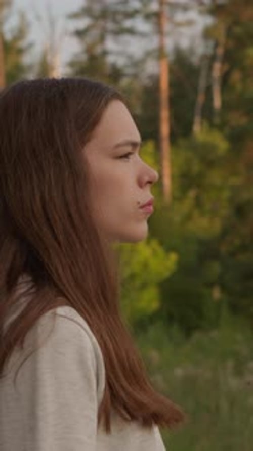 Mujer está de pie cerca del bosque por la noche