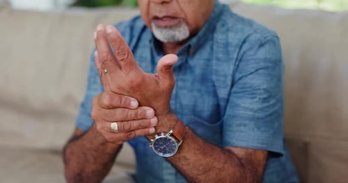Dolor en las manos, hombre mayor y en el sofá con artritis, desastre o crisis muscular, articular o en casa, Zoom