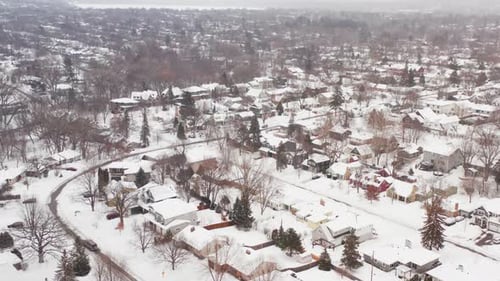 Aerial, snow covered houses in rural small town neighborhood suburb during winter