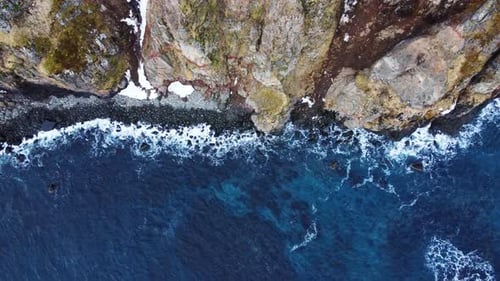 Flying Over Rocky Coastline Alongside Cliffside with Blue North Atlantic Ocean Water