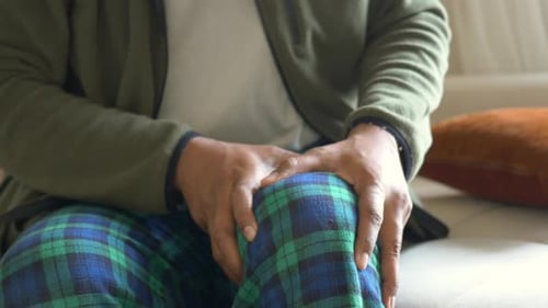 Homem que sofre dores nas articulações do joelho em casa
