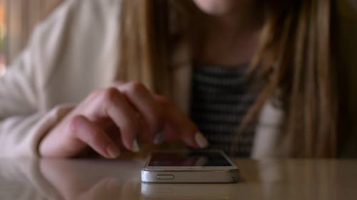 hands of girl using a mobile phone: teenager reads messages on smartphone