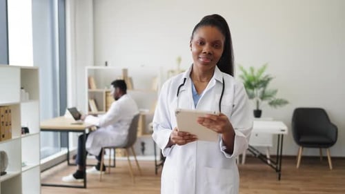 Profesional de la salud femenina que escribe en una tableta en un entorno clínico moderno
