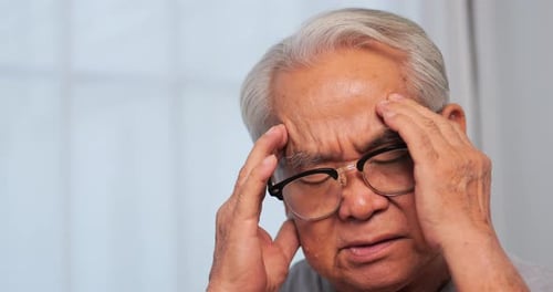 Anciano asiático con migraña. Anciano que sufre de dolor de cabeza.