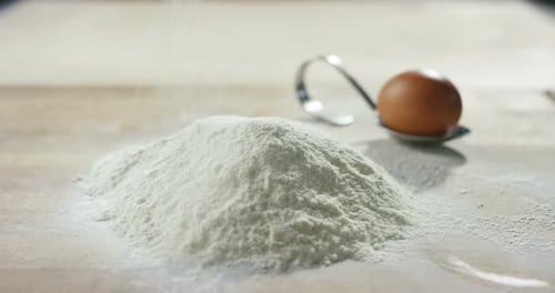 An experienced chef in a professional kitchen prepares the dough with flour to make the bio Italia