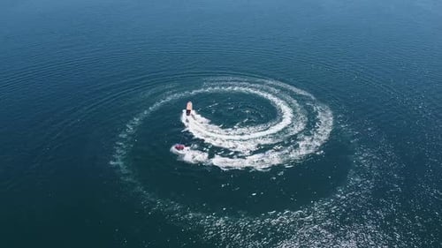 Caribbean aerial: Tourists enjoy bring towed on raft behind motorboat