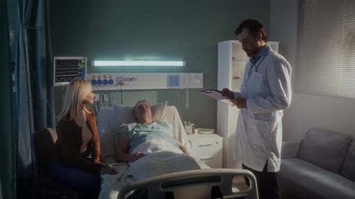 El médico consulta a una pareja mayor sobre la enfermedad en una cama de hospital