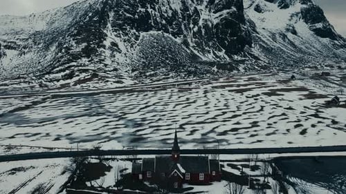 Above View Of Flakstad Church In Snowscape At Ramberg In Lofoten Islands, Norway. Aerial Drone Shot