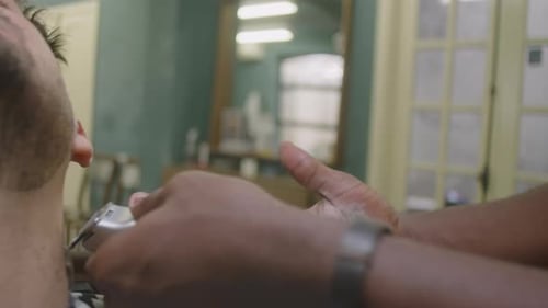 Barber Shaving Beard of Client with Electric Razor