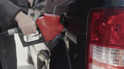 Der Besitzer des Autos füllt Benzin in den Tank