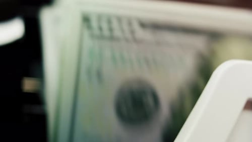 Close Up of Money Counting Machine Counting Hundred Dollar Bank Notes