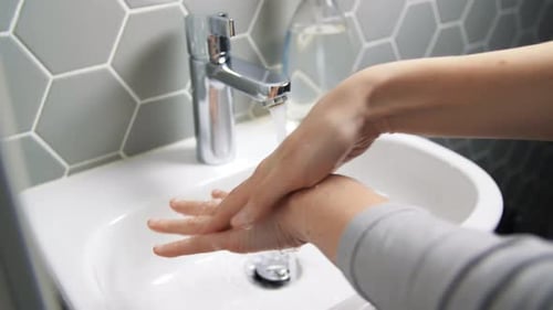 Woman washing hands with soap and water for hygiene and coronavirus prevention