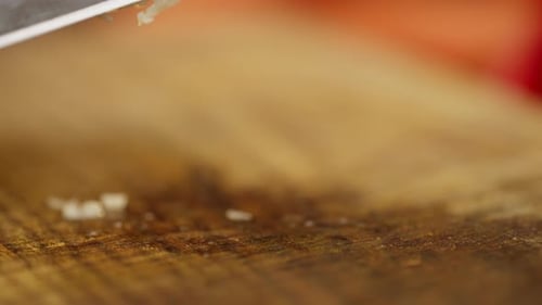 A Closeup of a Clove of Garlic Being Crushed with a Knife
