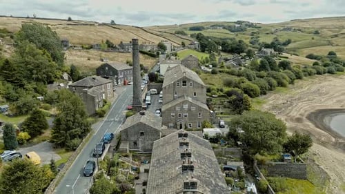 Vídeo aéreo de uma vila industrial rural com antigo moinho e chaminé. Filmado em Leeming