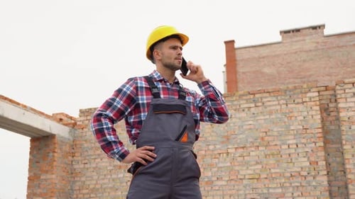 Construction Worker in Uniform and Safety Equipment Have Job on Building