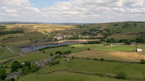 Vídeo aéreo de drone, filmagem de uma vila rural de Yorkshire com uma chaminé de moinho. Filmado em Leeming acima