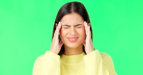 Stress, frustrated and a woman with a headache on a green screen isolated on a studio background