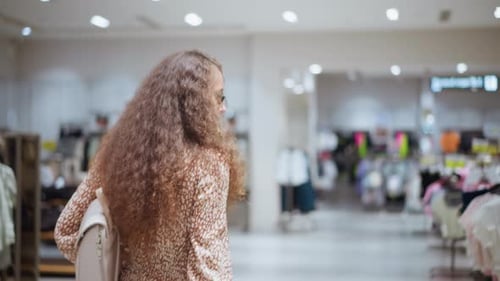 Woman Browsing Clothing Store with Bag