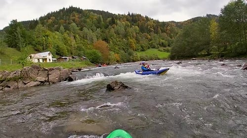 A Guy in a Kayak Sails on a Mountain River