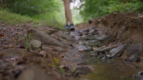 Female Legs Crossing River Water Flowing on Stones in Mountain