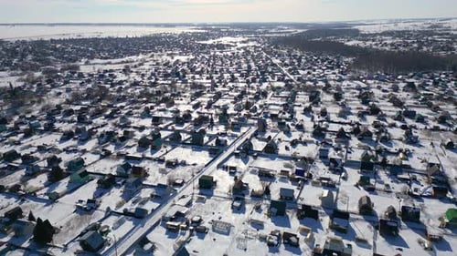 Aerial view of a Russian village covered by snow on a sunny winter day