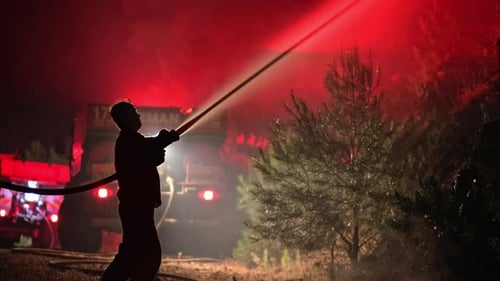 Firefighter Spray Water to Wildfire