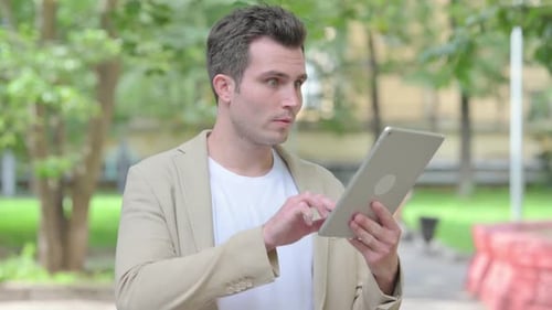 Joven casual con tableta al aire libre