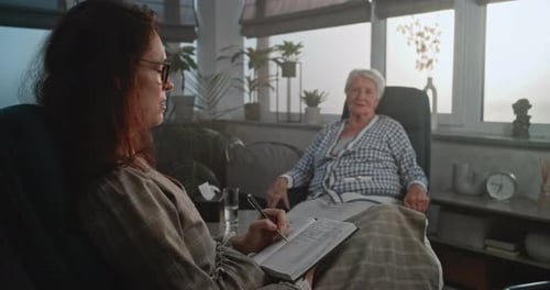 Una psicóloga escucha a un cliente mayor durante la cita